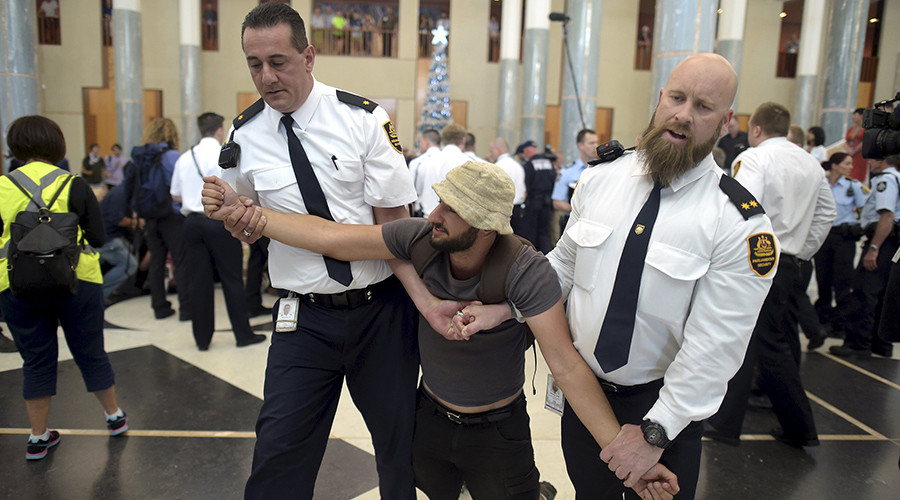 Security staff remove a protester from the main foyer of parliament during a climate change protest in Canberra, Australia, December 2, 2015