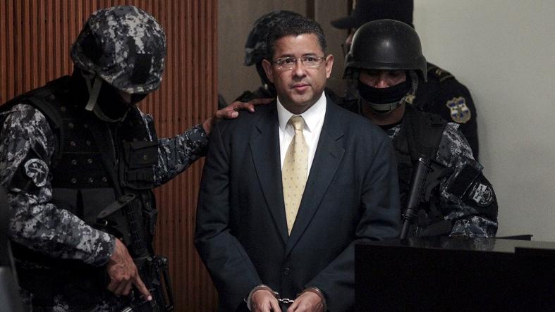 Former Salvadoran President Francisco Flores is escorted into court in handcuffs by officers of an elite police unit on Nov. 5, 2015.