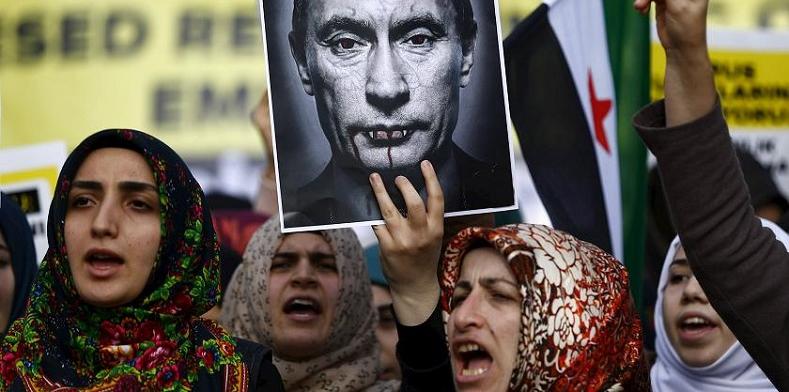 Demonstrators, holding a defaced poster of Russia's president Vladimir Putin, shout slogans during an anti-Russian protest in Istanbul, Turkey, Nov. 27, 2015.