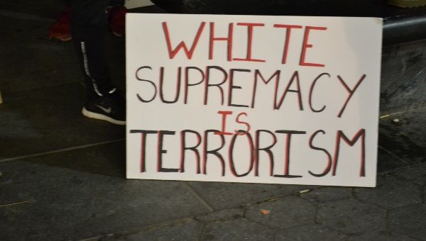 A banner condemns white supremacy as a form of terrorism.