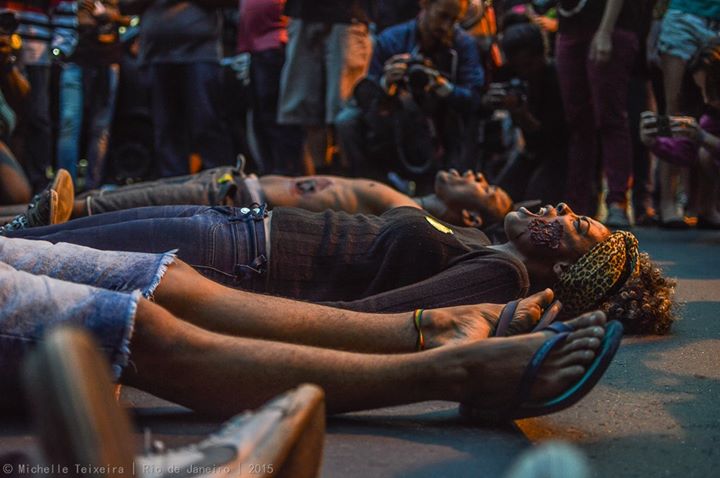 Protesters lie on the street with mock make up staging a symbolic performance representing the five murdered youth.