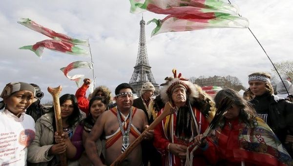 Indigenous leaders float down the Seine near the Eiffel Tower to demand true climate solutions amid the Paris COP21 on Dec. 6, 2015.