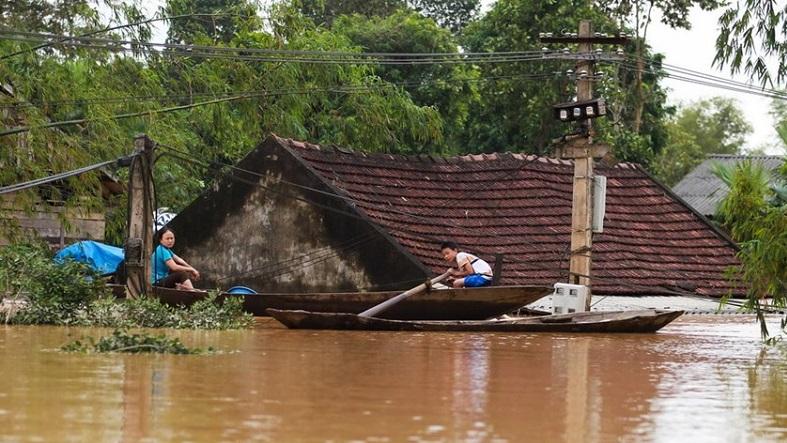 Villagers row past their flooded homes in the central province of Ha Tinh following Typhoon Nari in October 2013.