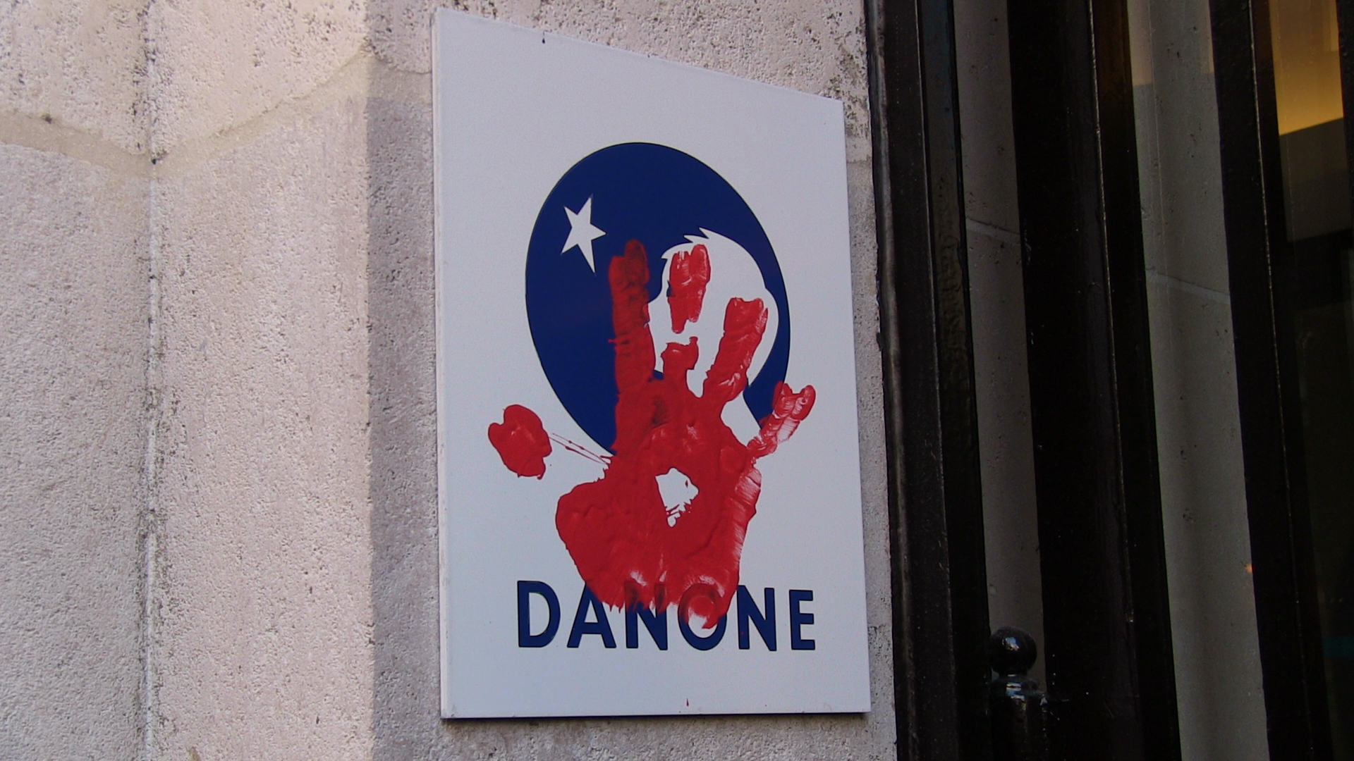Via Campesina protesters put their red hand print on Danone's logo expressing their demand that the company stop affecting campesinos worldwide.