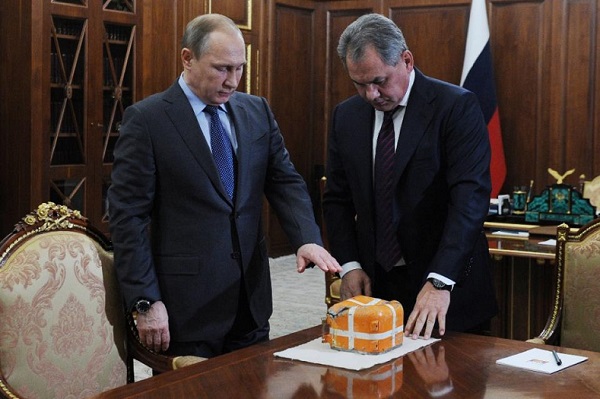 Russian President Vladimir Putin (L) and Defense Minister Sergei Shoigu examine the flight recorder from the Russian bomber shot down by a Turkish jet, Dec. 8, 2015.