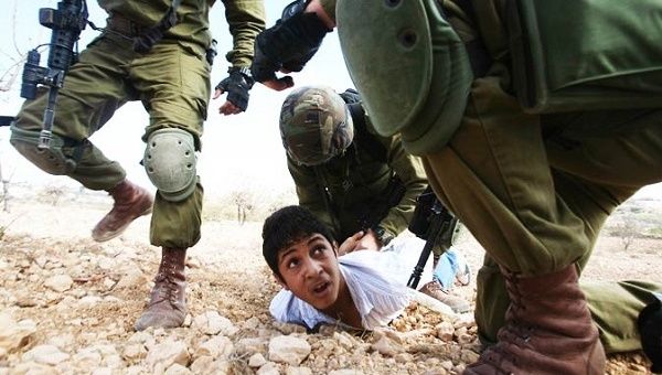 A Palestinian youth is arrested by Israeli soldiers during a protest against the Jewish settlement of Karmi Tsour on Oct. 23, 2010.