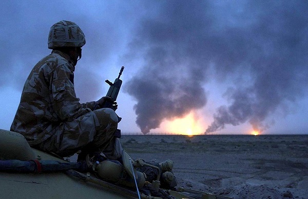 Photo shows a British soldier watching oil wells on fire in Southern Iraq in March 2003.