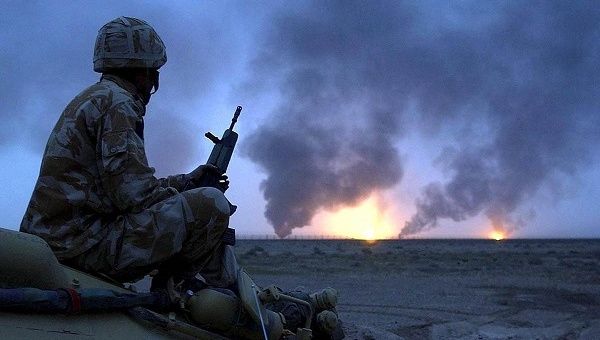 Photo shows a British soldier watching oil wells on fire in Southern Iraq in March 2003.