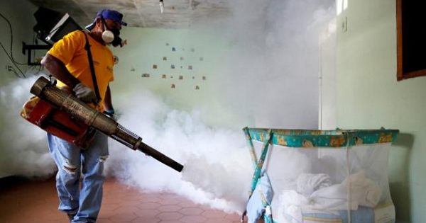 A worker from the municipality of Sucre fumigates a hospital to help control the spread of dengue fever in the Petare district of Caracas Sep. 22, 2014