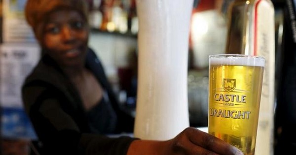 A bartender serves a beer produced by brewing company SAB Miller at a bar in Cape Town, Sept. 16, 2015