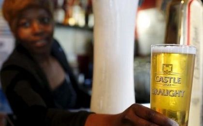 A bartender serves a beer produced by brewing company SAB Miller at a bar in Cape Town, Sept. 16, 2015 