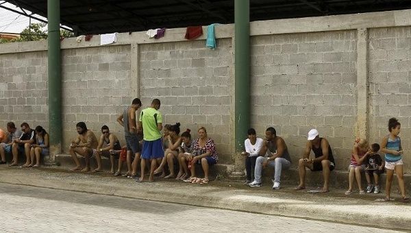 Cuban migrants sit outside of a temporary shelters in the town of La Cruz near the border between Costa Rica and Nicaragua, Nov. 18, 2015