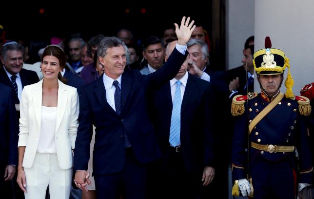 Argentina's President Mauricio Macri waves alongside First Lady Juliana Awada (L) next to an honour guard outside Buenos Aires' Cathedral in Buenos Aires, Argentina, December 11, 2015.