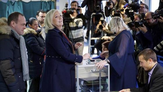 Marine Le Pen (2ndL), French National Front political party leader casts her ballot in the second round regional elections in Henin-Beaumont, France, Dec. 13, 2015.