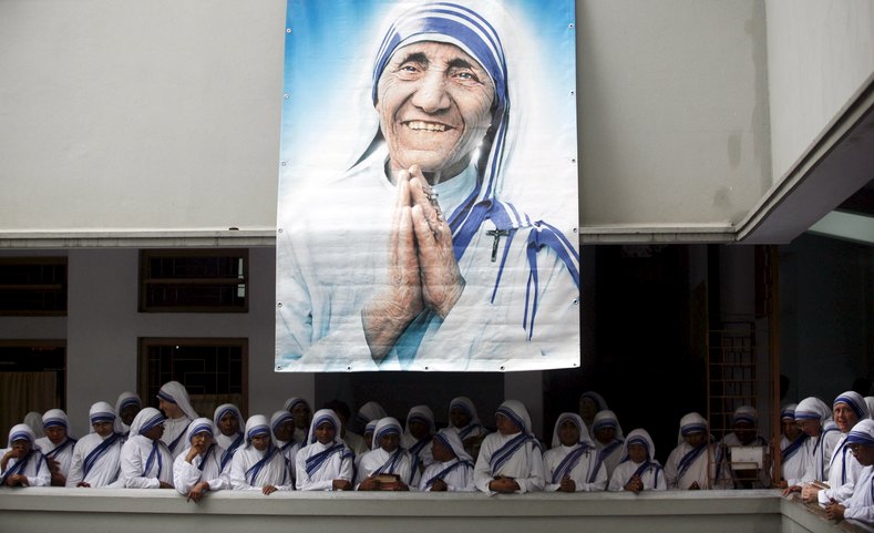 Catholic nuns from the order of the Missionaries of Charity gather under a picture of Mother Teresa during the 10th anniversary of her death in Kolkata, India.