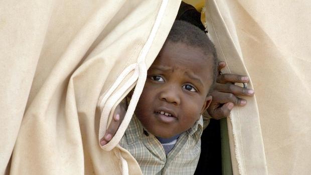 A Sudanese child takes a look from inside his tent at the Ruweished refugee on the Jordan-Iraq border 20 March 2003.