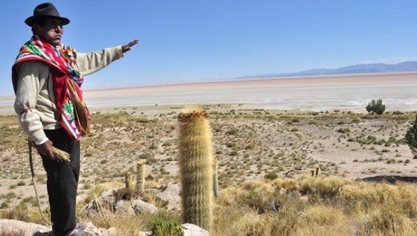A local resident gestures over Bolivia's dry Lake Poopo on Dec. 14, 2015.