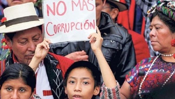 Protesters hold a sign saying “no more corruption