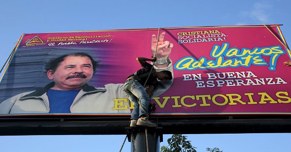 A worker places a banner promoting Nicaragua's President Daniel Ortega in Managua, Nicaragua Dec. 21, 2015.