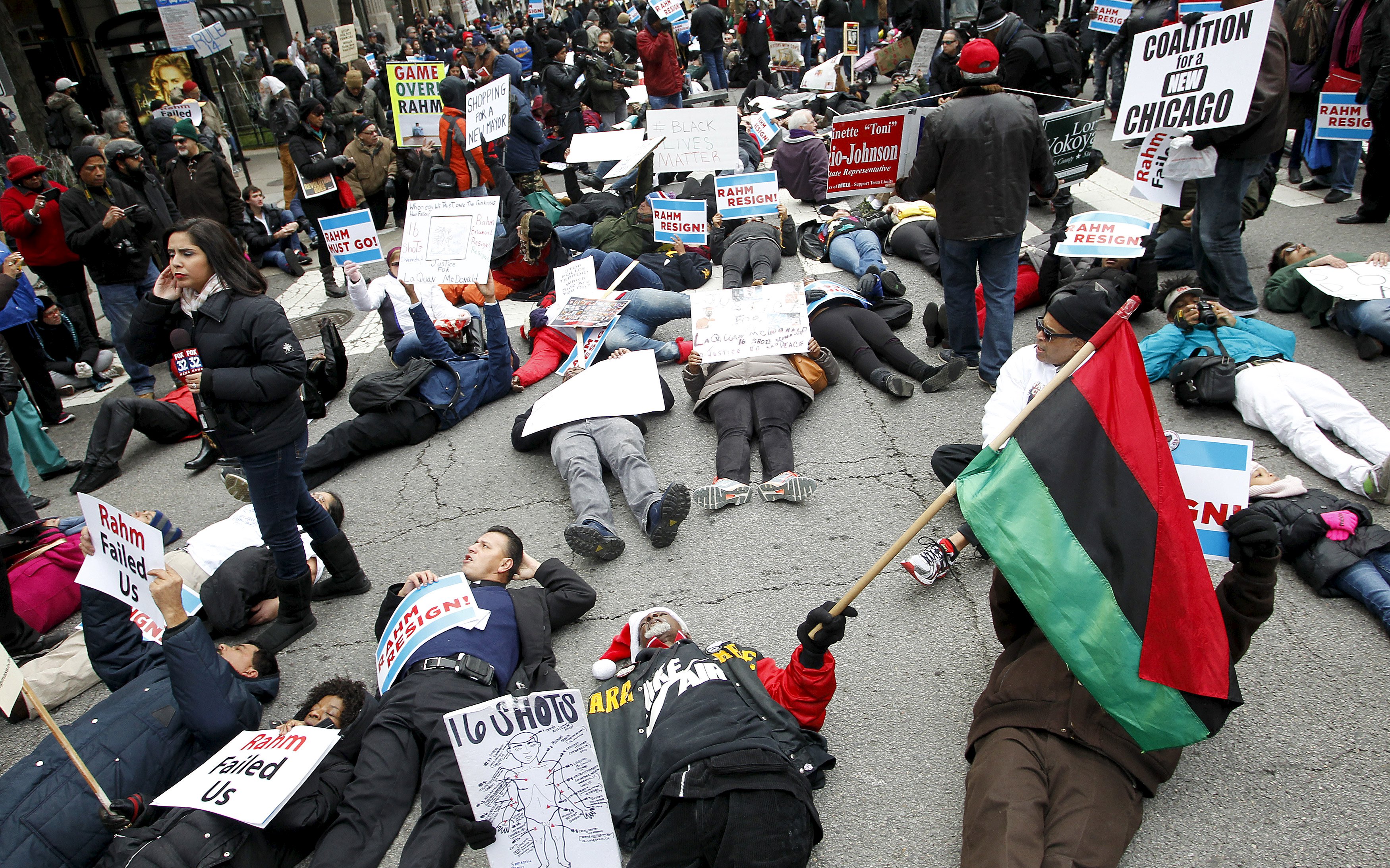 Protesters lie down on Chicago's Michigan Avenue in front of the Disney Store during a protest march against police violence in Chicago, Dec. 24, 2015