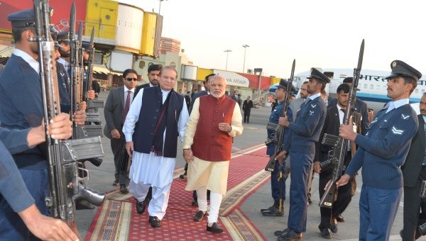 Pakistani Prime Minister Nawaz Sharif (L) walks with his Indian counterpart Narendra Modi after Modi's arrival in Lahore, Pakistan, December 25, 2015.