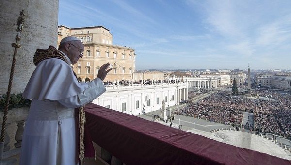 Pope Francis waves during the Christmas message from the balcony overlooking St. Peter's Square at the Vatican, Dec. 25, 2015
