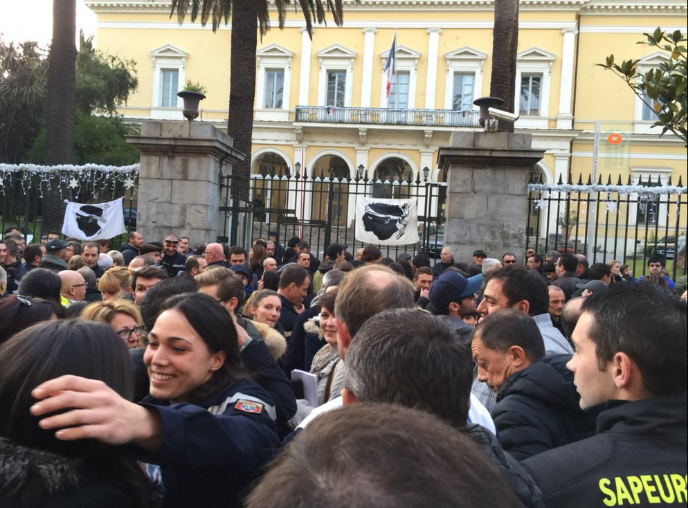 People gather in front of the regional administrative building in Ajaccio, before heading to the suburb where the firemen where allegedly injured by a group of young Muslims.