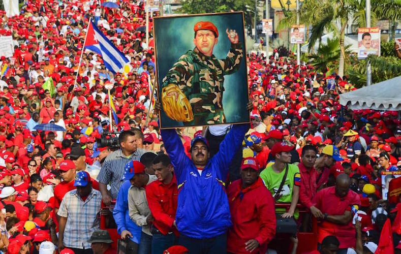 Venezuelan president Nicolas Maduro holds a picture of the late Venezuelan president Hugo Chavez during a rally in the port city of Catia La Mar, in northern Vargas state.