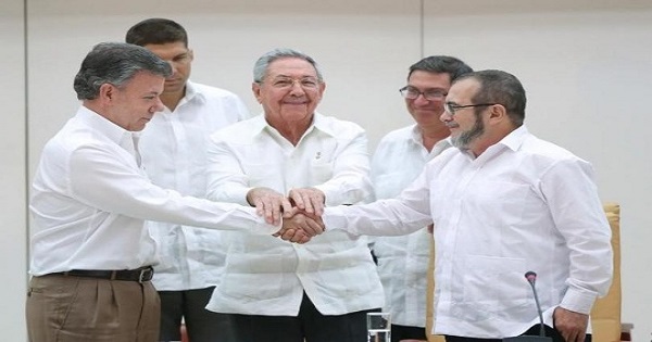 Cuban President Castro (C) oversees the handshake between Colombia's President Santos (L) and FARC leader 