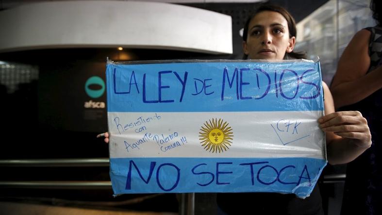 A demonstrator holds an Argentina flag with the message 