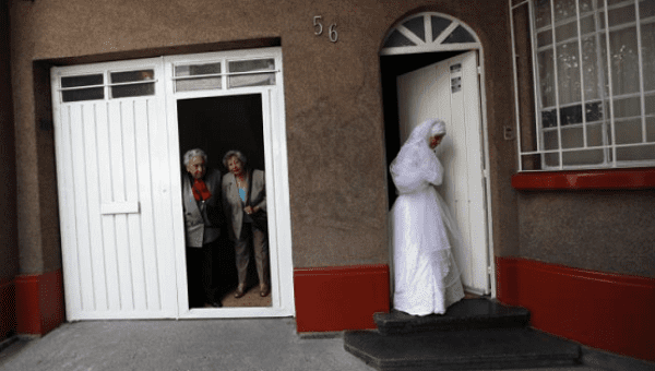 Adriana Marquez Nava (R), a Mexican Muslim convert, leaves her parents' home for her wedding as family members look on, Oct. 20, 2012. 
