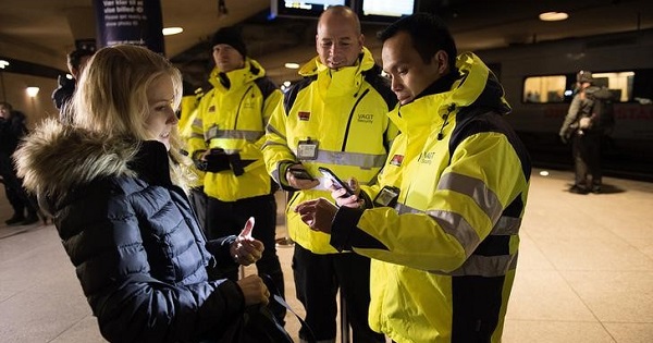 Security staff check a traveler's identification at Kastrups train station outside Copenhagen, Denmark.