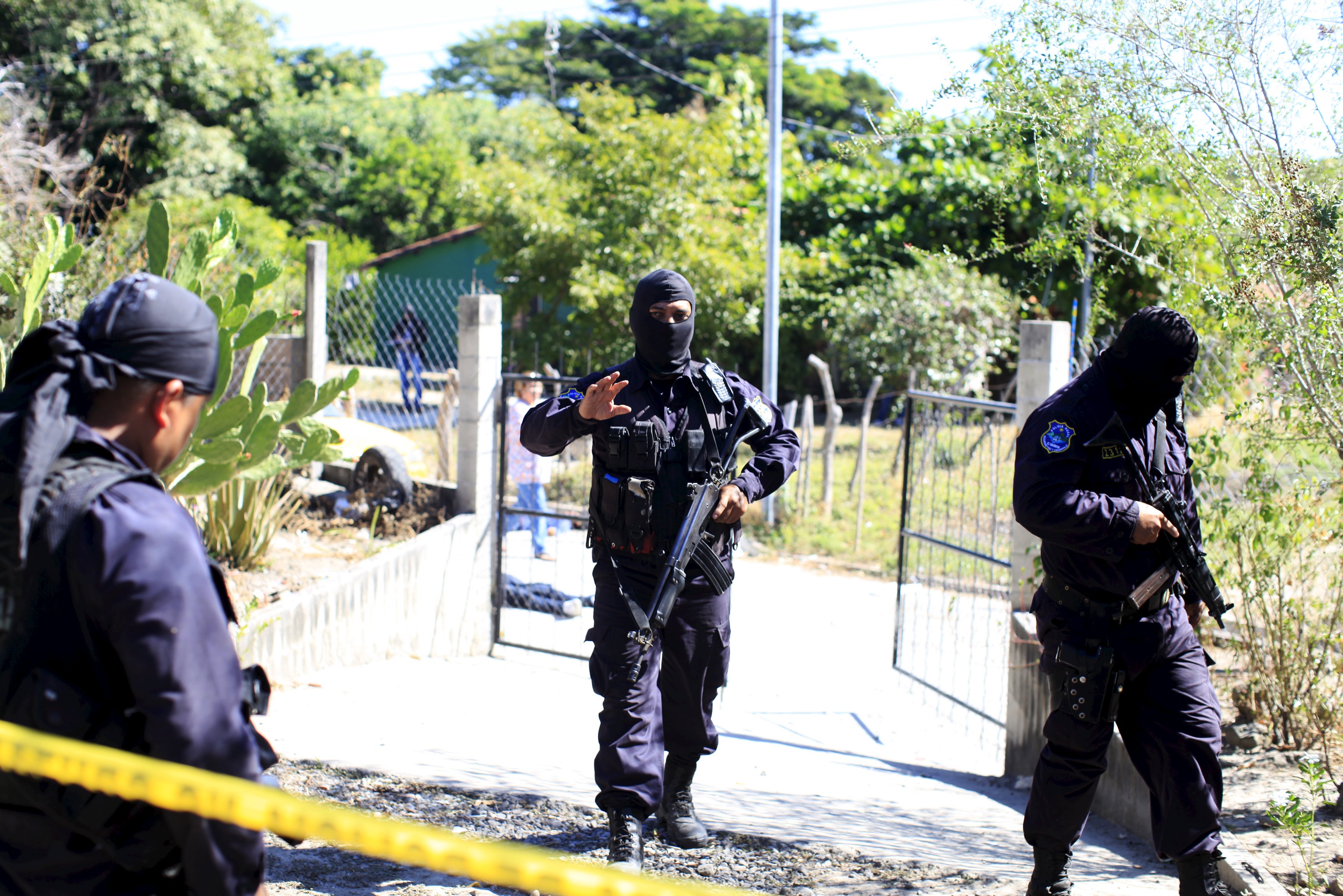Policemen secure a crime scene where five men were killed in the town of Olocuilta, El Salvador January 1, 2016.