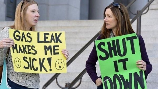 Porter Ranch residents Danielle Michaels (L) and Michelle Theriault (R) hold signs outside Los Angeles City Hall during a demonstration in Los Angeles, California Dec. 1, 2015.