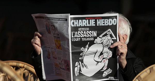 A man reads the latest edition of Charlie Hebdo with the title 
