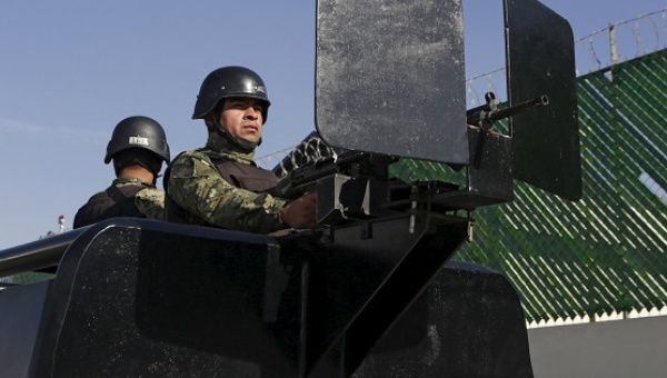 Mexican soldiers stand guard awaiting the arrival of recaptured drug lord Joaquin 