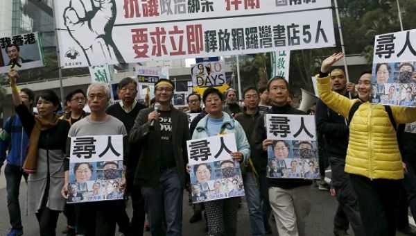 Demonstrators hold up portraits of five missing staff members of a publishing house and a bookstore during a protest over the disappearance of booksellers, in Hong Kong, China. The banner reads, 