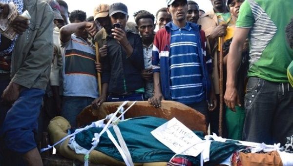 Ethiopians stand near the body of an Oromo protester who was allegedly shot dead by security forces in Wolenkomi, west of Addis Ababa.