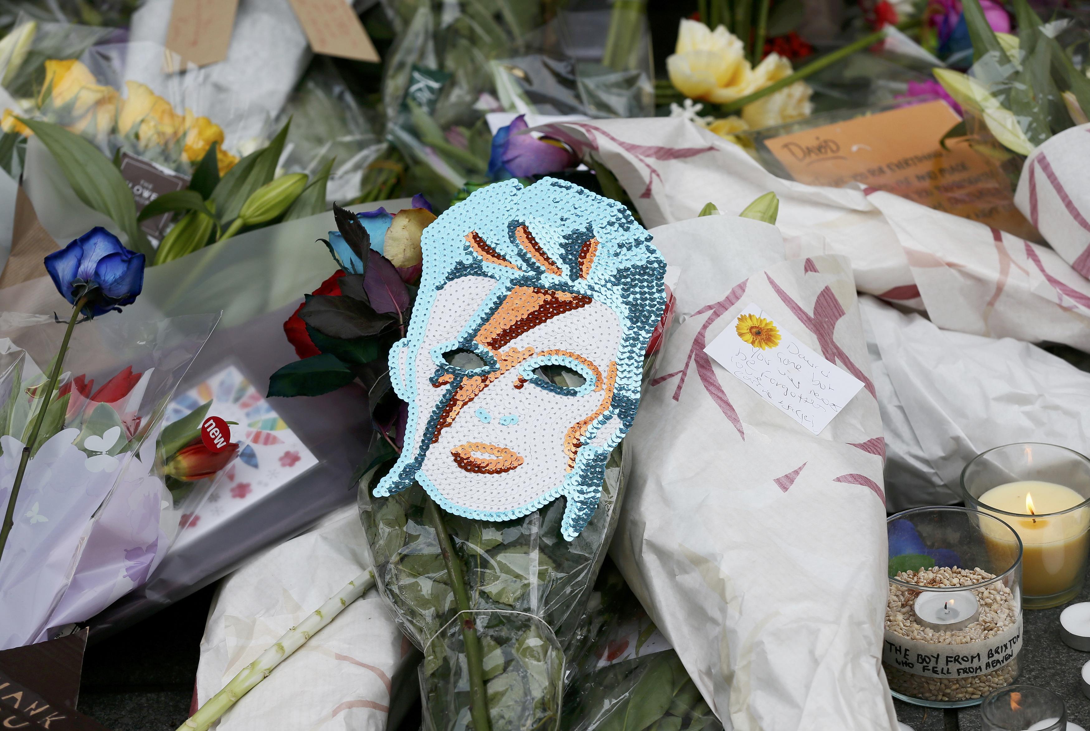 Flowers and tributes lie at a mural of David Bowie in Brixton, south London.