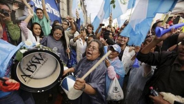 People react outside of the Guatemalan Congress building after the congress voted to strip President Otto Perez of immunity, in Guatemala City, Sept. 1, 2015.