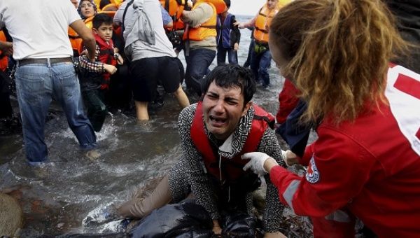 A Greek Red Cross volunteer comforts a crying Syrian refugee moments after disembarking from a flooded raft on the Greek island of Lesbos Oct. 20, 2015.