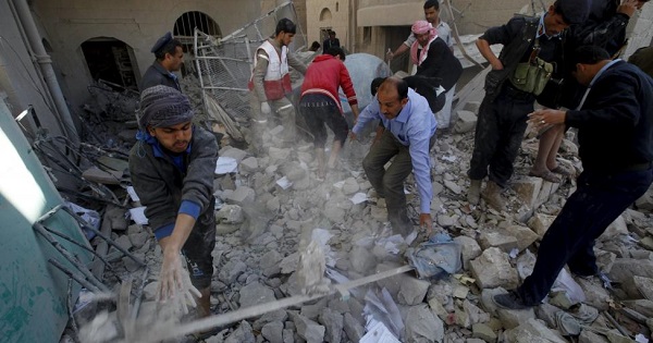 Policemen and medics remove debris as they search for victims at the site of a Saudi-led airstrike in Yemen's capital Sanaa, Jan. 18, 2016.