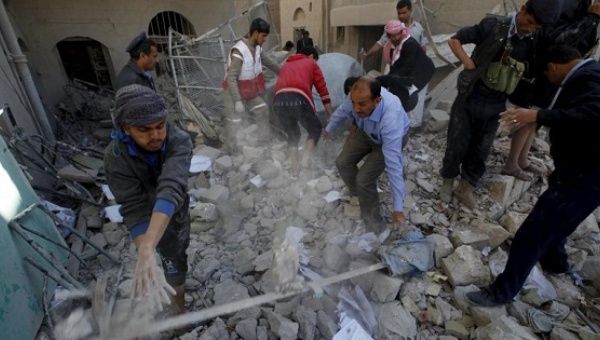 Policemen and medics remove debris as they search for victims at the site of a Saudi-led airstrike in Yemen's capital Sanaa, Jan. 18, 2016.