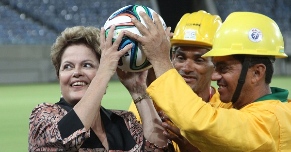 Brazilian President Dilma Rousseff (L) holds a soccer ball with workers during the inauguration of the Arena das Dunas stadium in Natal, Brazil, Jan. 22, 2014.