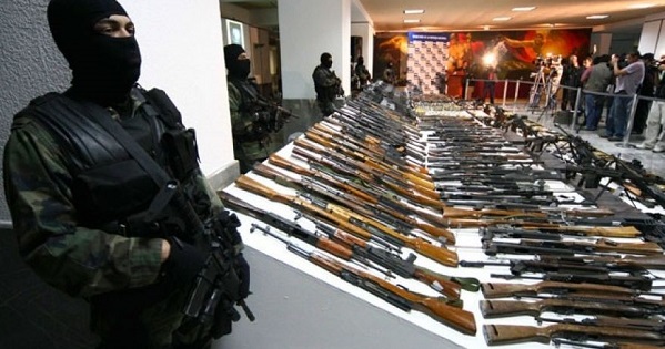 Soldiers stand guard near seized weapons during a news conference at the Defense Headquarters in Mexico City.