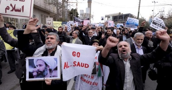 A protester holds a picture of Shi'ite cleric Sheikh Nimr al-Nimr, who was executed in Saudi Arabia, as others chant slogans during a rally, Tehran Jan. 8, 2016.