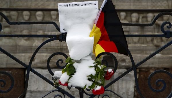 Snow-covered flowers and a German flag are pictured at the site of the suicide bomb attack at Sultanahmet square in Istanbul, Turkey January 19, 2016.