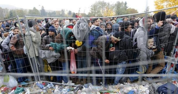A group of migrants queue to cross the border into Spielfeld in Austria from the village of Sentilj, Slovenia, Oct. 28, 2015.