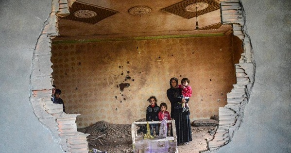 A woman and her children stand in the ruins of battle-damaged house in the Kurdish town of Silopi, in southeastern Turkey, near the border with Iraq on Jan. 19, 2016.