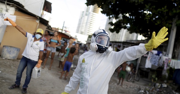 Municipal workers gesture before spraying insecticide at the neighborhood of Imbiribeira in Recife.